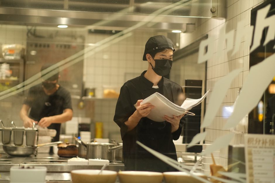 Chefs in a contemporary kitchen preparing dishes with focused precision.
